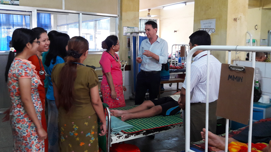 Ward round discussion with Dr Josh Hanson and Professor Mar Mar Kyi, surrounded by young Myanmar clinicians