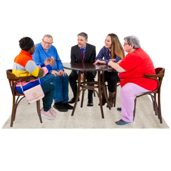 Diverse group of people sitting around a table talking. Credit: Photosymbols