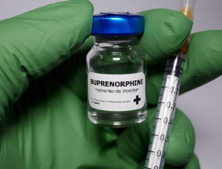Green gloved hand holding buprenorphine and syringe Credit: Hailshadow, iStock