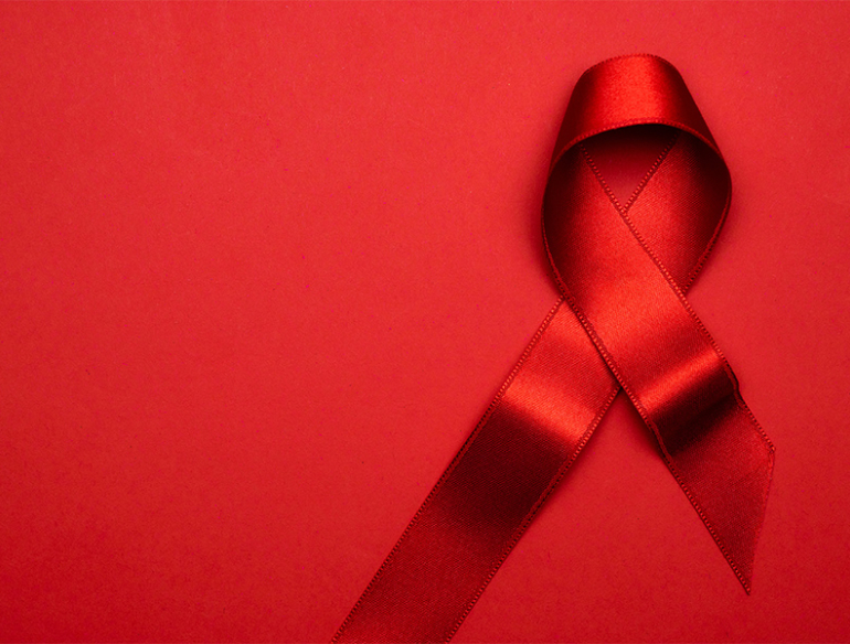 Red AIDS ribbon on red background