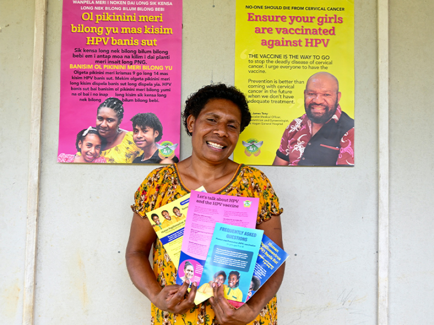 HPV vaccine data entry clerk Regina Jim holding health promotion materials.