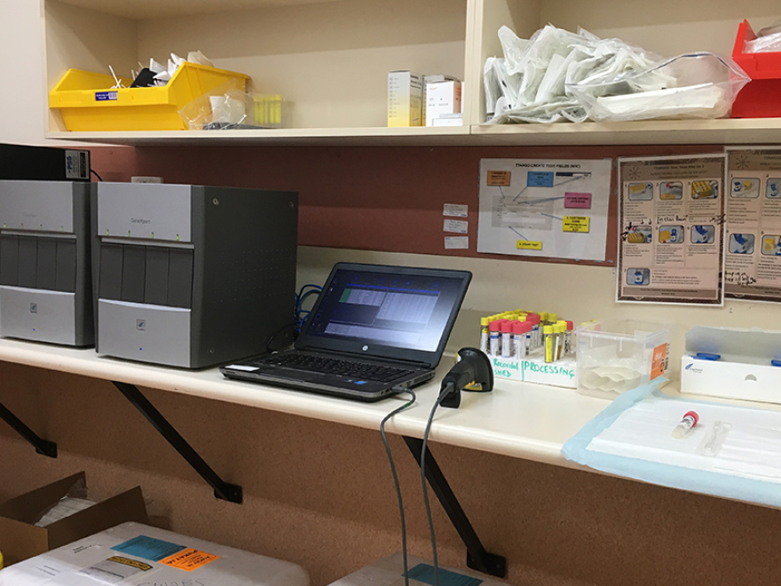 A laptop surrounded by medical equipment in a small clinic setting