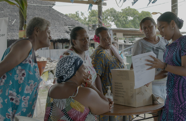 Aisha, a logistics officer, at an outreach clinic in Vanuatu explaining to a group of women about cervical cancer. 